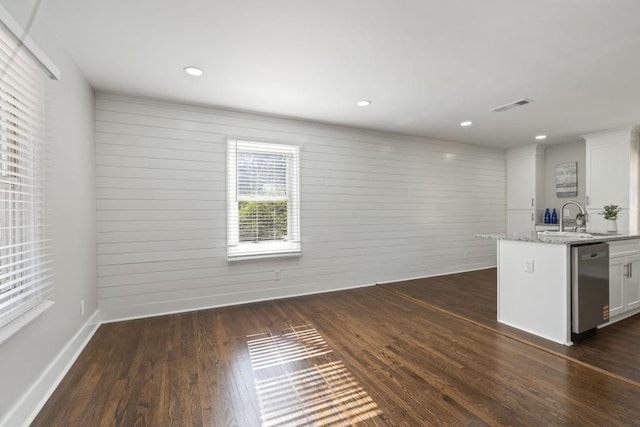 kitchen featuring dark hardwood / wood-style floors, light stone countertops, dishwasher, and white cabinets