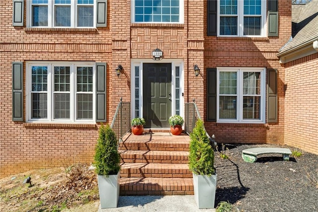 doorway to property featuring brick siding