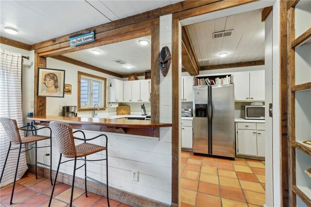 kitchen featuring a healthy amount of sunlight, appliances with stainless steel finishes, and white cabinets