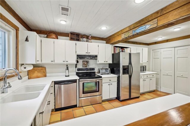 kitchen with stainless steel appliances, range hood, sink, white cabinetry, and light hardwood / wood-style floors