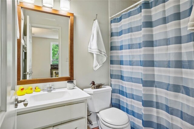 bathroom featuring vanity, toilet, and walk in shower