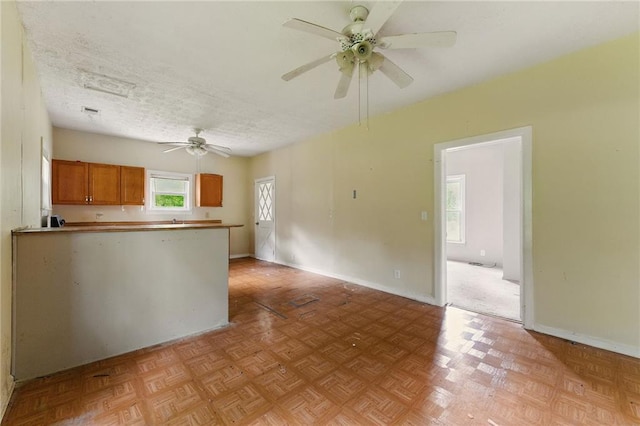 232 Polk Ave, Dallas, GA 30132 - kitchen with a ceiling fan, brown cabinets, a peninsula, and baseboards