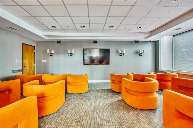 carpeted home theater with a paneled ceiling