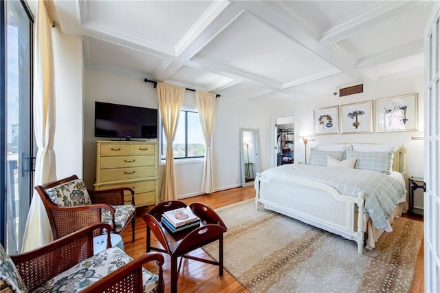 bedroom featuring coffered ceiling, wood finished floors, and beamed ceiling