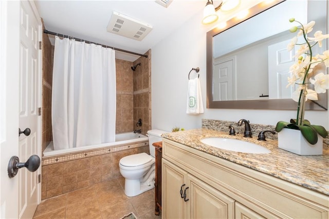 bathroom with visible vents, toilet, tiled shower / bath combo, vanity, and tile patterned floors