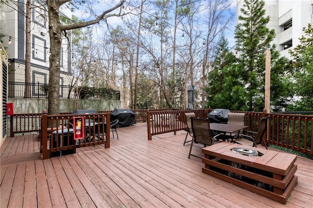 deck featuring outdoor dining space and grilling area