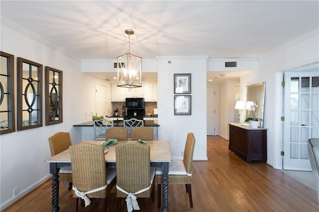 dining space featuring crown molding, visible vents, and wood finished floors