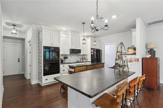 411 Johnson Rd, Locust Grove, GA 30248 - kitchen with black appliances, a center island, dark countertops, a chandelier, and decorative backsplash