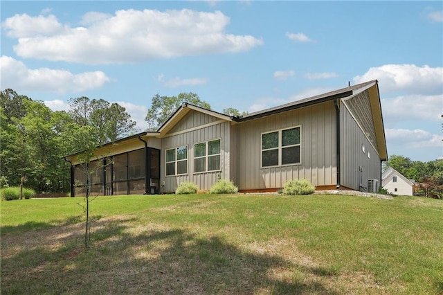 411 Johnson Rd, Locust Grove, GA 30248 - rear view of house with board and batten siding, a lawn, and a sunroom