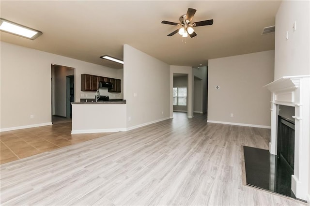 unfurnished living room with ceiling fan and light hardwood / wood-style floors