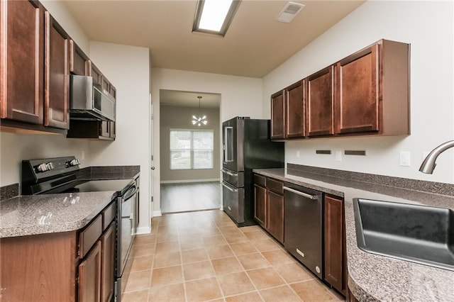 kitchen with stainless steel appliances, an inviting chandelier, and sink