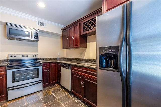 kitchen with stainless steel appliances, crown molding, dark countertops, reddish brown cabinets, and recessed lighting