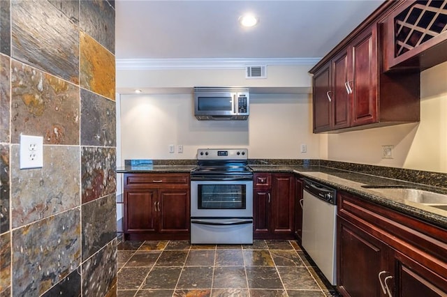kitchen with appliances with stainless steel finishes, crown molding, dark brown cabinets, dark stone counters, and recessed lighting