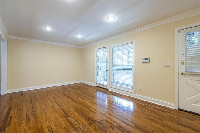 spare room with crown molding, baseboards, wood finished floors, and recessed lighting
