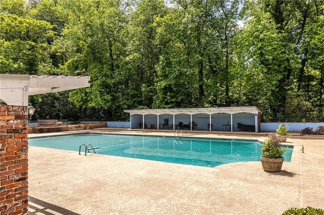 view of pool with a patio and fence