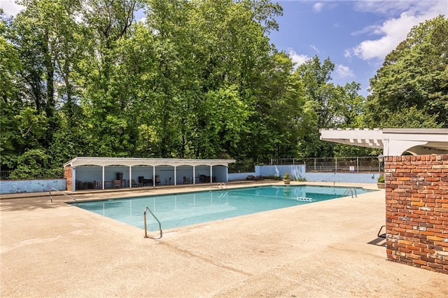community pool featuring fence and a patio area