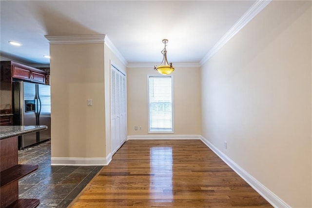 unfurnished dining area featuring crown molding, baseboards, and dark wood-type flooring