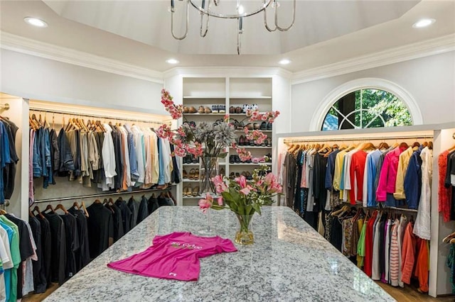 walk in closet with an inviting chandelier