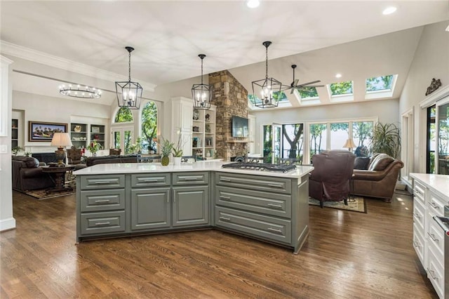 kitchen with a kitchen island, gray cabinetry, open floor plan, and light countertops