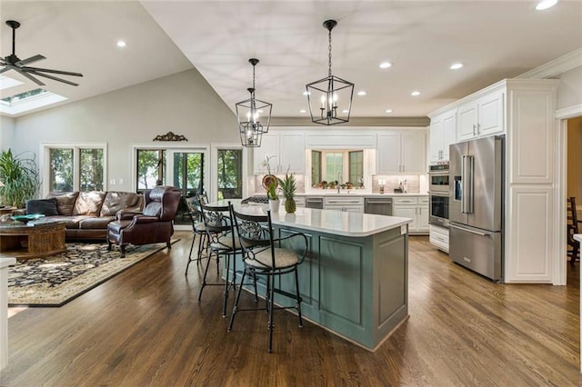 kitchen with dark wood finished floors, open floor plan, light countertops, white cabinets, and stainless steel appliances