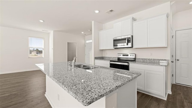 kitchen featuring stainless steel appliances, a center island with sink, and white cabinets