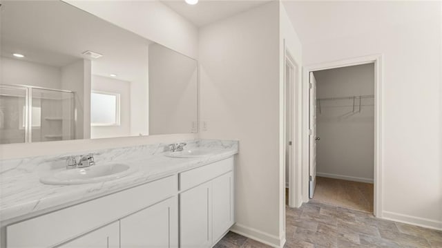 bathroom with vanity and a shower with door