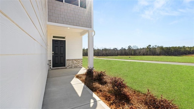 view of exterior entry with a yard