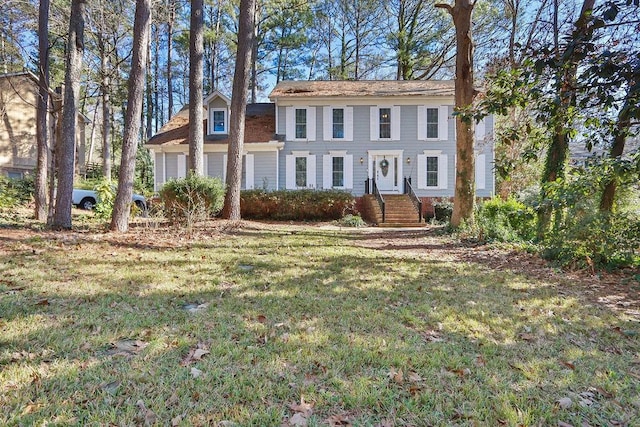 colonial-style house featuring a front yard