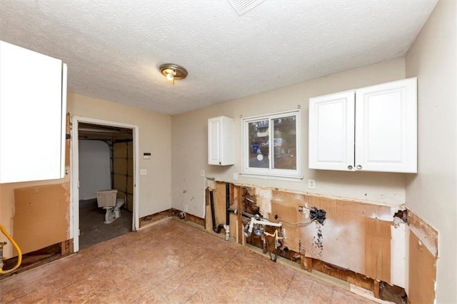 clothes washing area featuring a textured ceiling