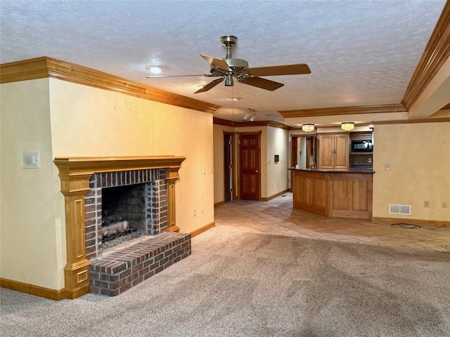 unfurnished living room with a ceiling fan, crown molding, light colored carpet, baseboards, and a fireplace