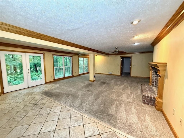 unfurnished living room featuring a ceiling fan, ornamental molding, baseboards, a brick fireplace, and a textured ceiling
