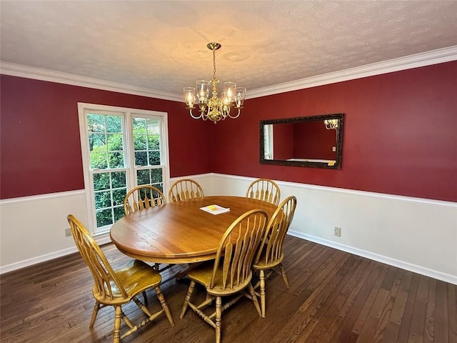 dining area featuring a chandelier, hardwood / wood-style floors, wainscoting, crown molding, and baseboards