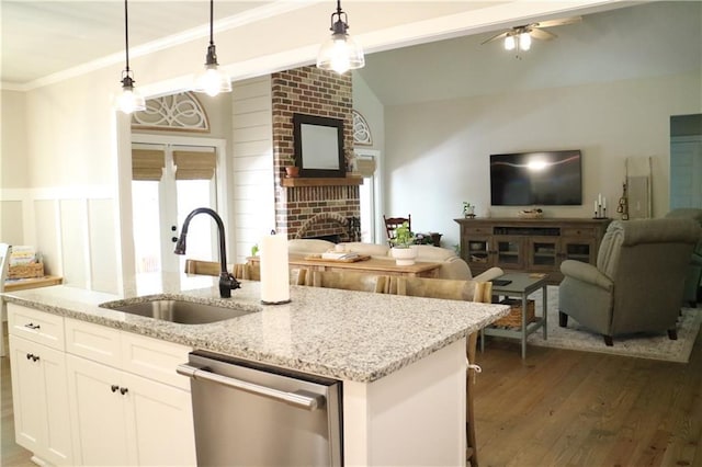 kitchen featuring dishwasher, white cabinets, decorative light fixtures, and sink