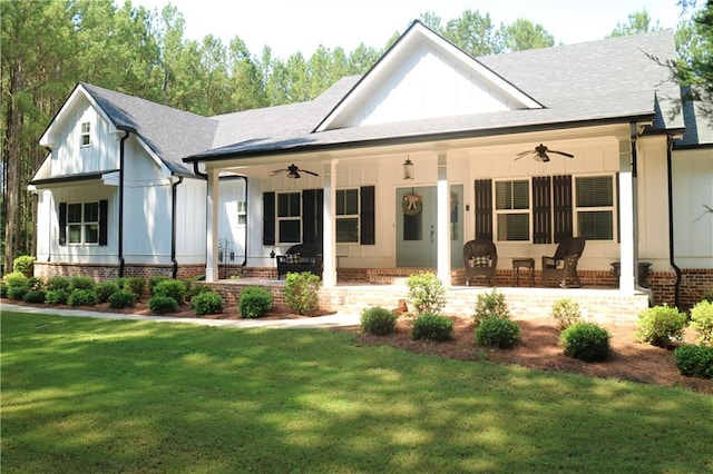 view of front of house featuring ceiling fan, a front lawn, and covered porch