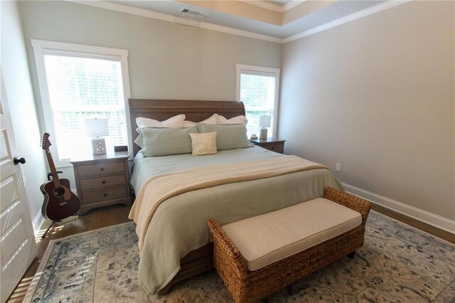 bedroom with dark hardwood / wood-style floors, multiple windows, and crown molding