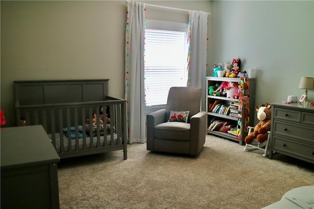 carpeted bedroom featuring a nursery area