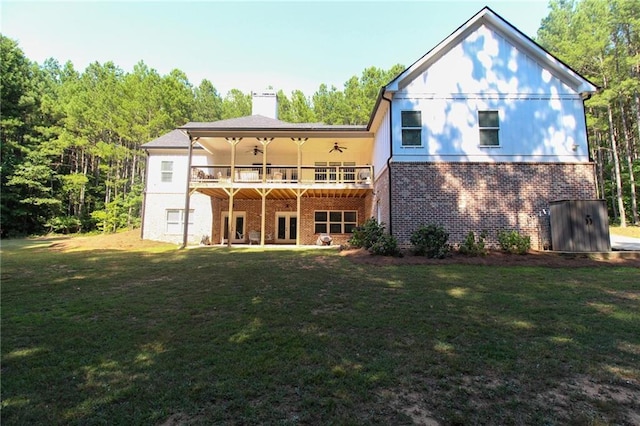 rear view of property with a lawn, ceiling fan, and a deck