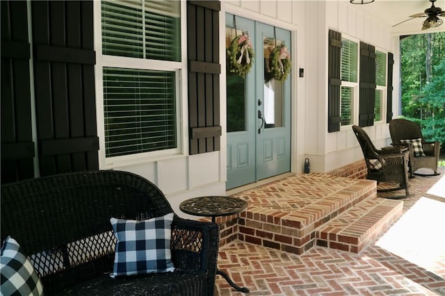 entrance to property featuring ceiling fan, covered porch, and french doors