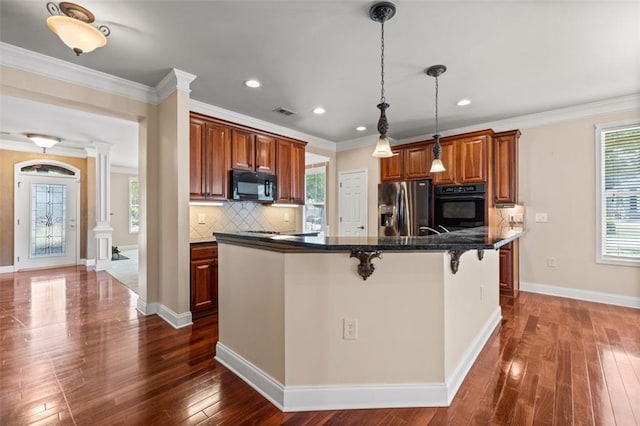 6350 Manningtree Ct, Cumming, GA 30041 - kitchen featuring black appliances, a breakfast bar, dark wood-style flooring, tasteful backsplash, and decorative columns