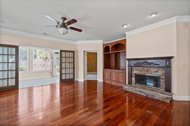 6350 Manningtree Ct, Cumming, GA 30041 - unfurnished living room with wood finished floors, a stone fireplace, a ceiling fan, baseboards, and crown molding