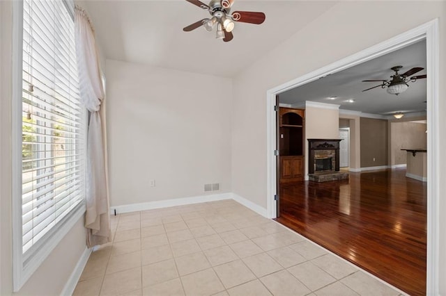 6350 Manningtree Ct, Cumming, GA 30041 - unfurnished room featuring ceiling fan, baseboards, a fireplace, wood finished floors, and ornamental molding