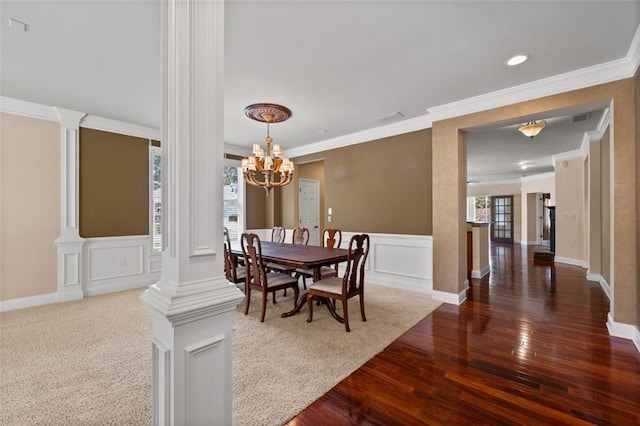 6350 Manningtree Ct, Cumming, GA 30041 - dining space with crown molding, dark wood-type flooring, a chandelier, ornate columns, and a decorative wall