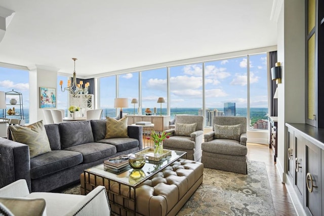 living area with an inviting chandelier, crown molding, wood finished floors, and a water view