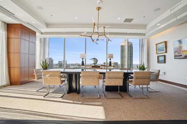 dining room with a city view, light carpet, visible vents, and a chandelier
