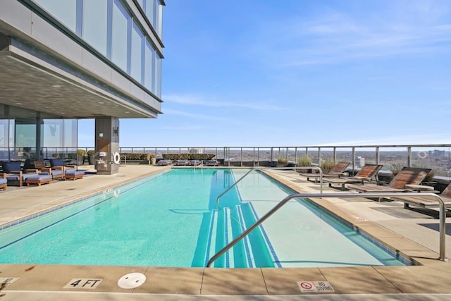 community pool with fence and a patio