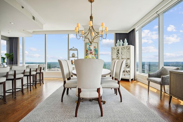dining area with plenty of natural light, visible vents, wood finished floors, and a notable chandelier