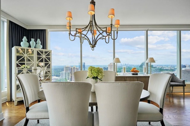 dining room with wood finished floors, a chandelier, and a view of city