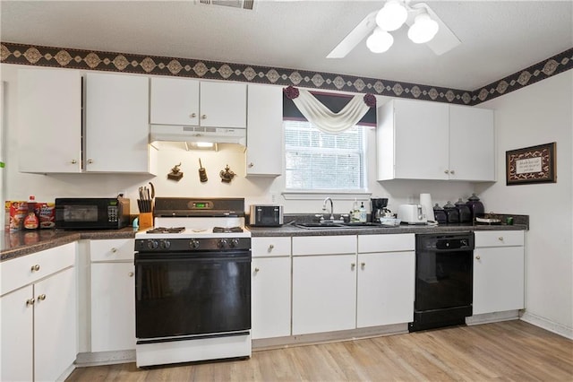 3405 Spring Chase Ln, Ellenwood, GA 30294 - kitchen with black appliances, under cabinet range hood, dark countertops, and light wood-style floors