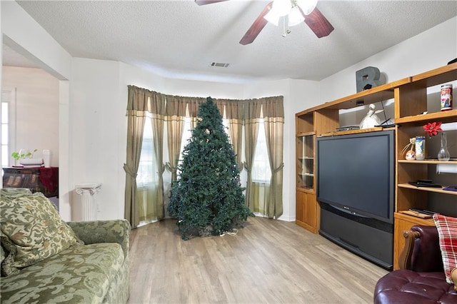 3405 Spring Chase Ln, Ellenwood, GA 30294 - living area featuring light wood-style floors, a ceiling fan, a textured ceiling, and radiator heating unit