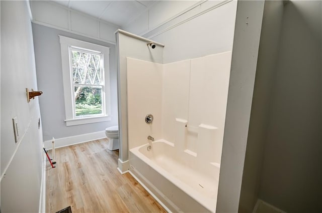 bathroom featuring toilet, bathtub / shower combination, and hardwood / wood-style floors